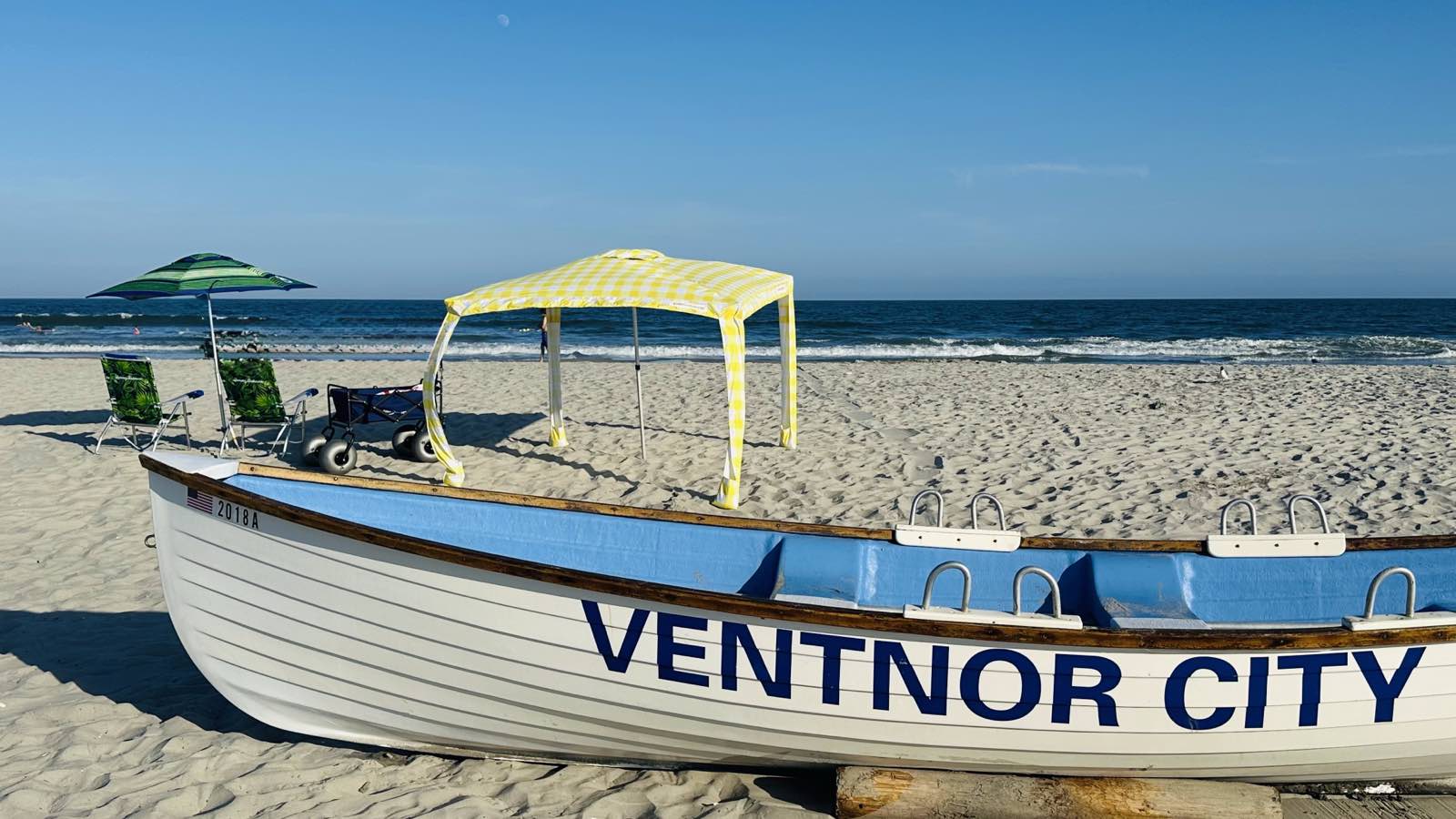 A fully set-up beach spot with chairs, umbrella, and shade canopy on the sand in Ventnor City, NJ